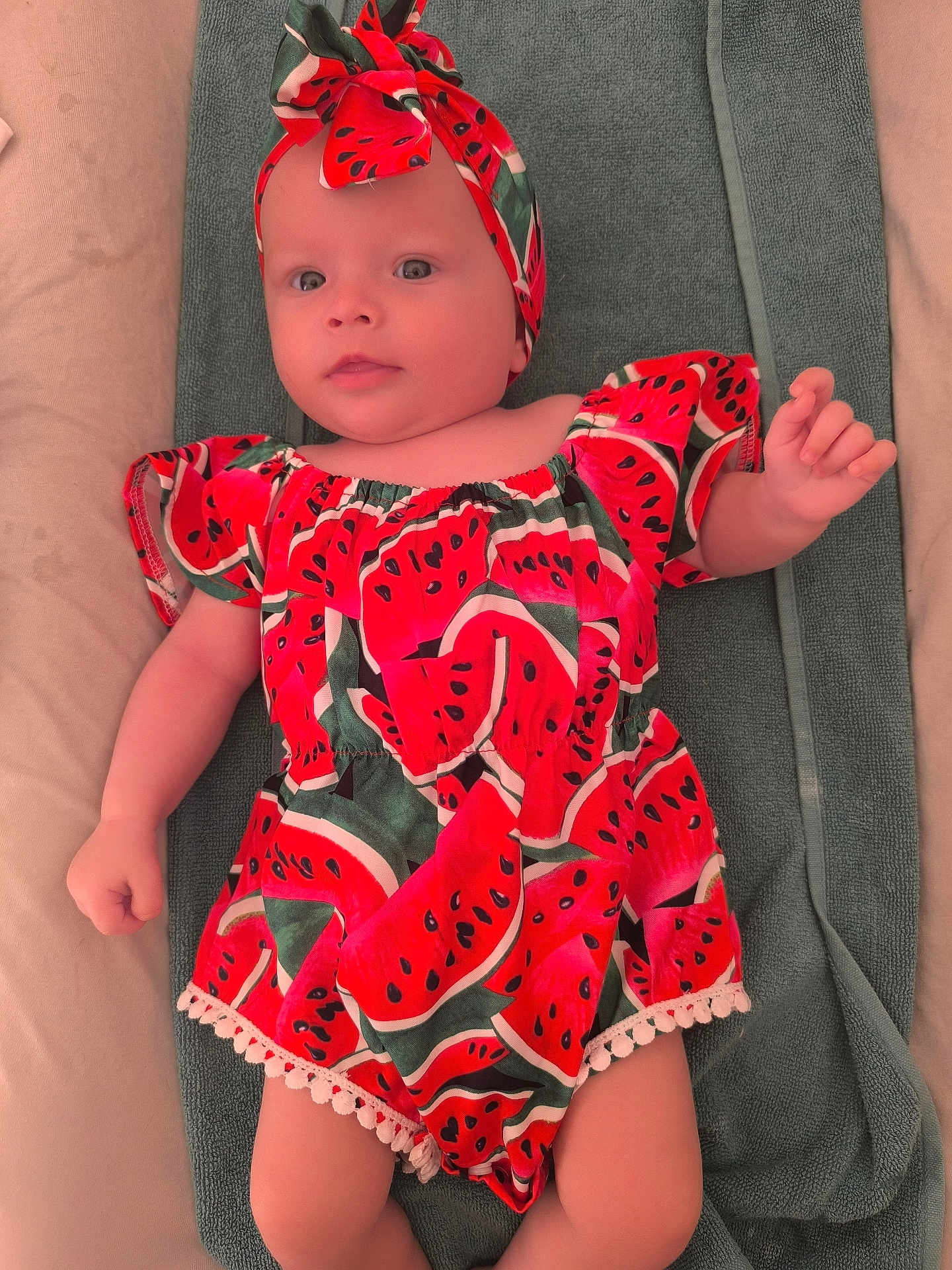 Iris participe au concours pour gagner de l'argent avec cette photo : baby, infant, watermelon_pattern, headband, clothing, towel, lying_down, cute, child, portrait, skin, hand, face, eyes, mouth, smile, indoor, fabric, colorful, young