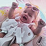 Iris a rejoint le concours — aidez-le/la à gagner de superbes lots ! baby, infant, sunglasses, pink, inflatable_ring, water, pool, smiling, happy, child, summer, outdoor, sunlight, floating, fun, swim, playful, cute, raising_hands, protection