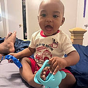 Jordan joined the competition — help win amazing prizes! baby, bed, bedroom, child, clothing, curly_hair, door, elephant_toy, expression, feet, fire_truck, happy, indoor, infant, open_mouth, person, play, shirt, sitting, toy