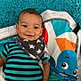 baby, infant, smile, striped_shirt, bib, stars, play_mat, cartoon_octopus, blue, teal, orange, fabric, child, cute, happy, lying_down, indoors, face, person, young
