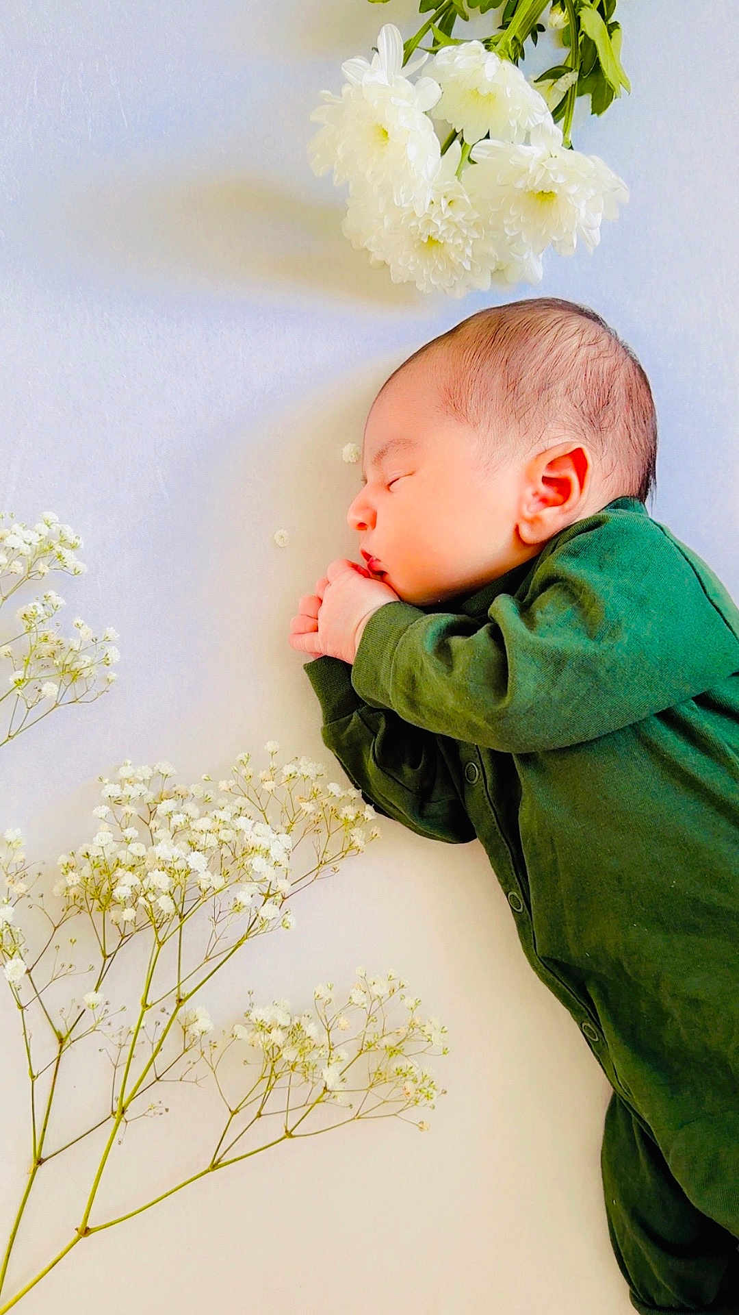 Muhammad joined the competition — help win amazing prizes! baby, newborn, sleeping, green_clothing, flowers, white_flowers, peaceful, infant, soft_light, portrait, side_view, cute, small_hands, delicate, nature, calm, resting, closeup, fresh, tender
