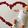 Muhammad is registered to the contest to win money with this photo: baby, infant, rose_petals, heart_shape, white_onesie, panda_design, sock, lying_down, cute, soft_surface, red_petals, decorative, adorable, child, toddler, portrait, indoors, skin, expression, peaceful