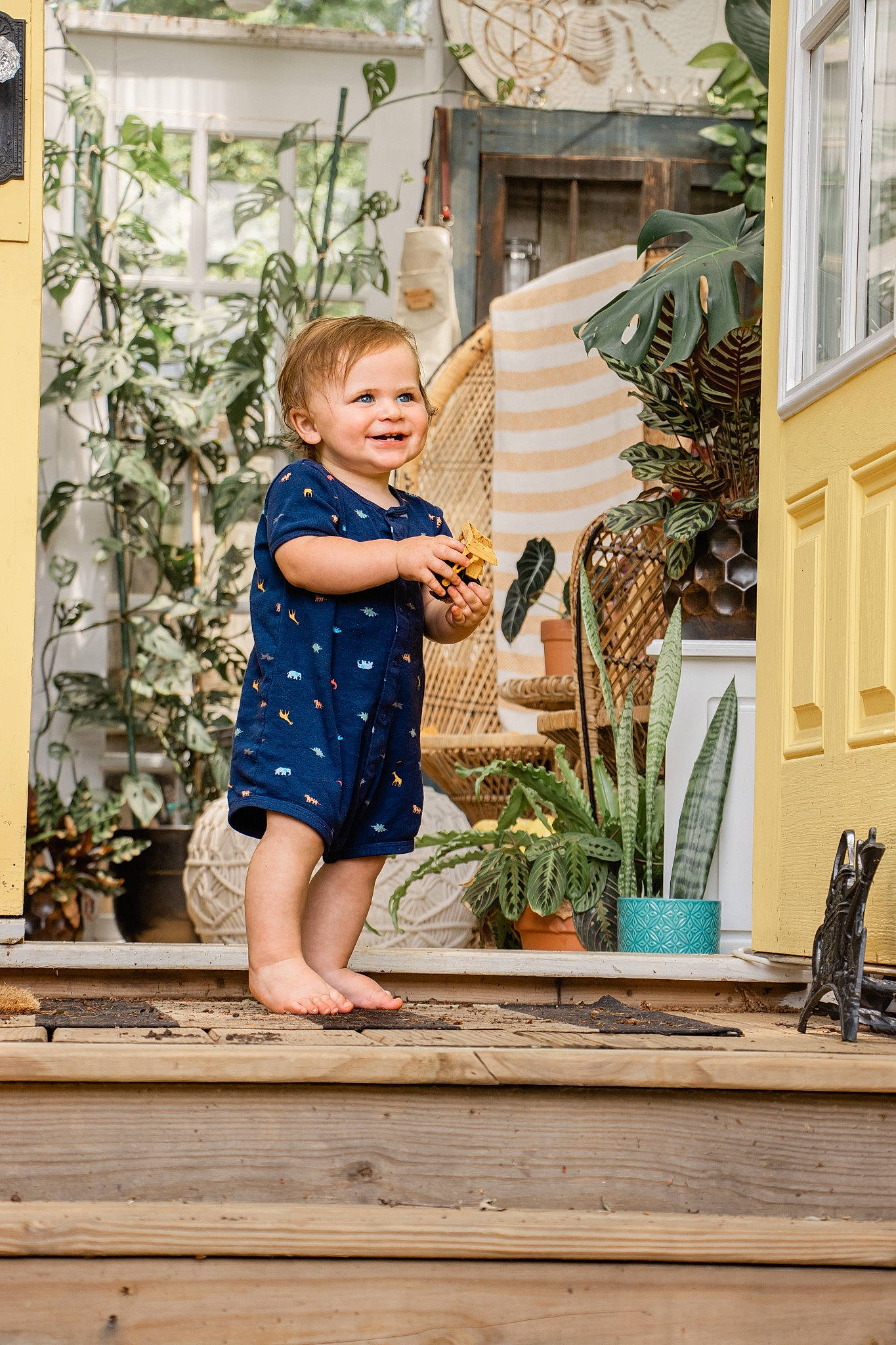 Gideon is registered to the contest to win money with this photo: azure, baby, baby_toddler_clothing, child, daytime, flooring, flowerpot, grass, happy, houseplant, joy, leg, leisure, person, plant, skin, smile, summer, toddler, vertebrate