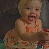 baby, child, smiling, tongue_out, headband, flower, dress, sitting, couch, indoors, happy, cute, playful, person, infant, heart_emoji, colorful, young_child, portrait, fun