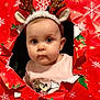 baby, child, christmas, costume, curious, cute, face, festive, headband, holiday, holiday_decor, indoor, portrait, red_background, reindeer_ears, seasonal, snowflake_pattern, torn_paper, wrapping_paper, young_child