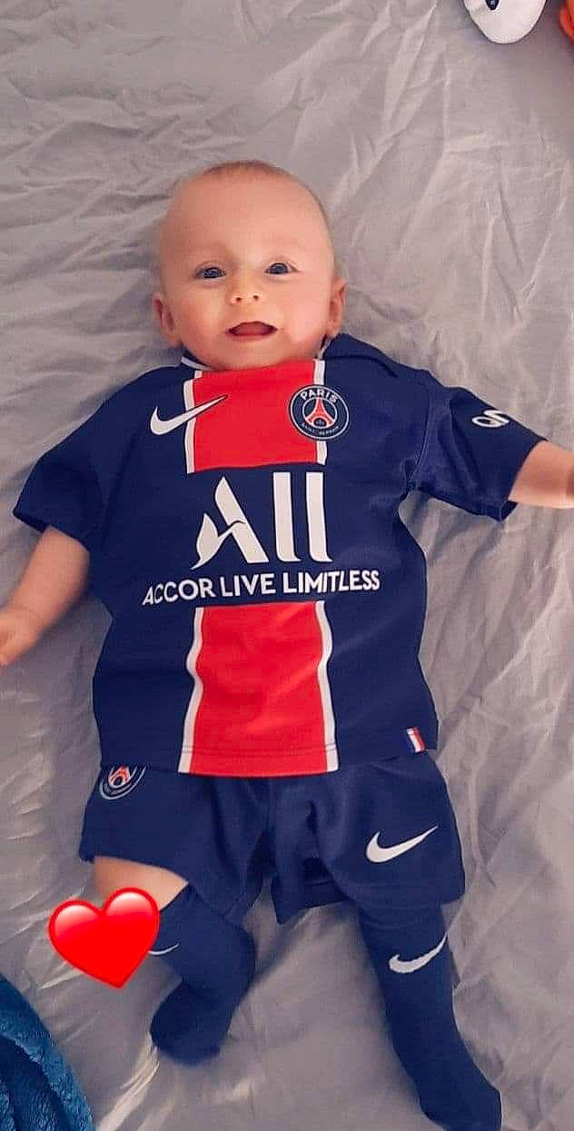 Raphaël a rejoint le concours — aidez-le/la à gagner de superbes lots ! baby, baby_toddler_clothing, electric_blue, flooring, fun, happy, jersey, long_sleeved_t_shirt, outerwear, person, personal_protective_equipment, player, red, sleeve, sports_jersey, sports_uniform, sportswear, t_shirt, textile, thigh