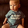 baby, blue_shirt, casual_clothing, child, couch, curious, cute, expression, face, furniture, indoors, infant, legs, mamas_boy, portrait, short_hair, sitting, skin, toddler, young