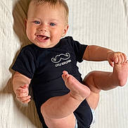 Alden joined the competition — help win amazing prizes! baby, child, infant, smiling, onesie, black_clothing, mustache_graphic, text, little_gentleman, lying_down, kicking_legs, happy, blue_eyes, short_hair, indoor, white_background, cute, diaper, skin, person