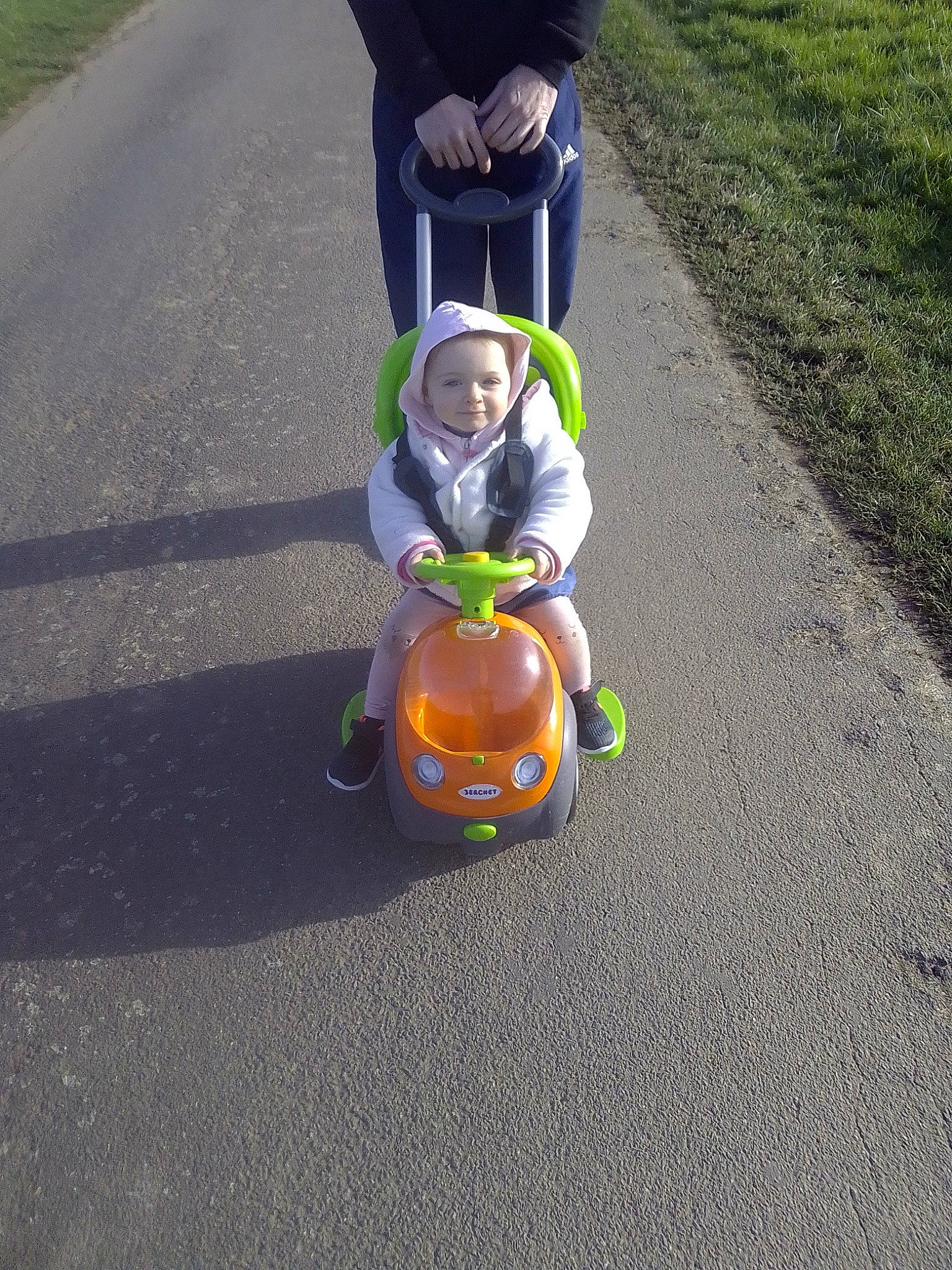 Mya participe au concours pour gagner de l'argent avec cette photo : asphalt, automotive_wheel_system, baby, baby_products, child, grass, joy, leisure, motor_vehicle, person, recreation, riding_toy, road, road_surface, rolling, sidewalk, sitting, snapshot, toddler, toy