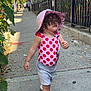 Ella'Mia is registered to the contest to win money with this photo: toddler, child, sidewalk, urban, street, brownstone, hat, swimsuit, curly_hair, walking, sunny, daytime, fence, plants, trees, people, shoes, clothing, outdoor, building