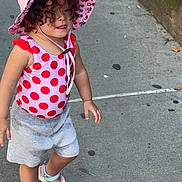 Ella'Mia is registered to the contest to win money with this photo: toddler, child, sidewalk, pink_hat, polka_dot, swimsuit, sandals, curly_hair, outdoor, summer, walking, concrete, sunhat, cute, playful, casual_clothing, person, young_child, daytime, urban