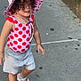 toddler, child, sidewalk, pink_hat, polka_dot, swimsuit, sandals, curly_hair, outdoor, summer, walking, concrete, sunhat, cute, playful, casual_clothing, person, young_child, daytime, urban