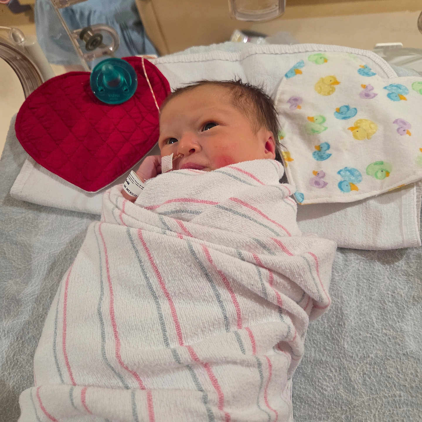 Mariska joined the competition — help win amazing prizes! baby, babycare, bed, blanket, cloth, cute, duck, face, healthcare, heart, hospital, infant, lying_down, medical, nasal_tube, newborn, pattern, person, red, swaddled