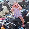 Amaya joined the competition — help win amazing prizes! toddler, child, motorcycle, sunglasses, outdoor, sunny, tree, van, playful, colorful_clothing, pink_shoes, sidewalk, vehicle, summer, happy, baby, person, seat, daytime, accessory