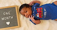 Kasei is registered to the contest to win money with this photo: baby, baby_clothing, blanket, blue_onesie, celebration, child, cute, firetruck, heart, indoors, infant, laying_down, letter_board, milestone, newborn, one_month, person, portrait, resting, soft_texture