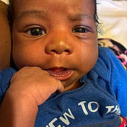 Kasei is registered to the contest to win money with this photo: baby, infant, close_up, face, hand, blue_shirt, curious_eyes, chubby_cheeks, person, portrait, skin, indoors, cute, child, young, expression, looking_at_camera, sitting, clothing, newborn
