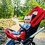 Britax, baby, child, clothing, daytime, family, footwear, greenery, happy, helmet, nature, outdoor, park, path, person, rocks, smile, stroller, sunlight, trees