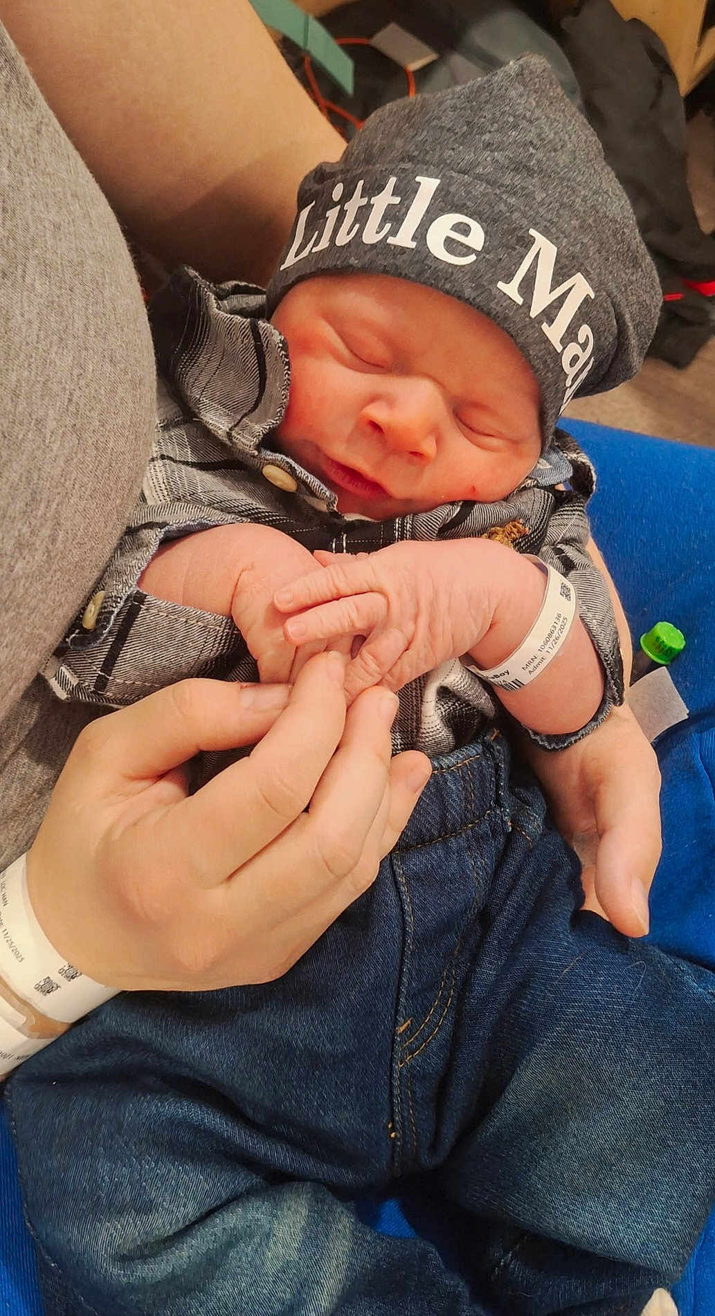 Hunter is registered to the contest to win money with this photo: newborn, baby, infant, hat, clothing, plaid_shirt, jeans, hand, holding, hospital_wristband, sleeping, cute, tender, peaceful, portrait, indoor, person, newborn_baby, closeup, family