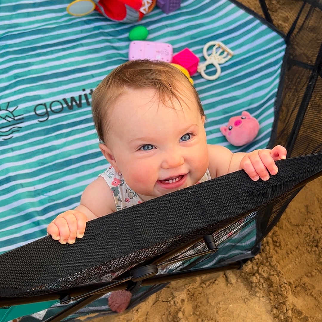 Charlie joined the competition — help win amazing prizes! baby, blanket, blue_eyes, cheerful, child, clothing, colorful, cute, face, grip, hand, happy, infant, mesh, outdoor, play, playpen, sand, smiling, toy