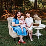 woman, baby, boy, family, outdoor, forest, grass, armchair, blue_dress, white_shirt, shorts, table, dried_flowers, book, smile, sunlight, nature, portrait, happy, casual