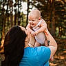 baby, woman, child, outdoor, forest, trees, nature, smile, happy, holding, person, casual_clothing, daylight, portrait, family, parent, infant, skin, tattoo, blue_shirt