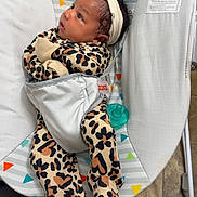 Amora joined the competition — help win amazing prizes! baby, infant, leopard_print, onesie, headband, bow, baby_bouncer, animal_print, giraffe, alligator, bird, pacifier, floor_tiles, indoor, curious, strapped_in, colorful, cute, child, newborn