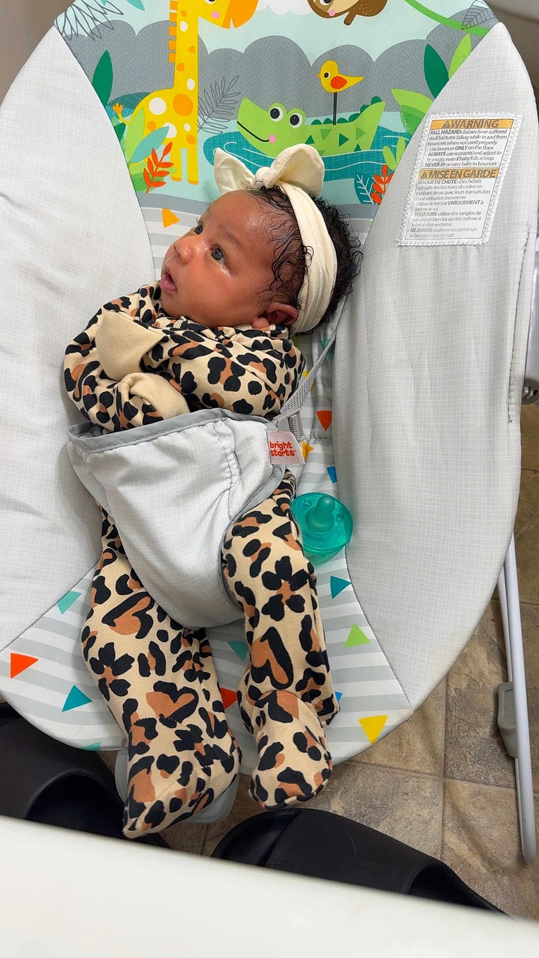 Amora joined the competition — help win amazing prizes! baby, infant, leopard_print, onesie, headband, bow, baby_bouncer, animal_print, giraffe, alligator, bird, pacifier, floor_tiles, indoor, curious, strapped_in, colorful, cute, child, newborn