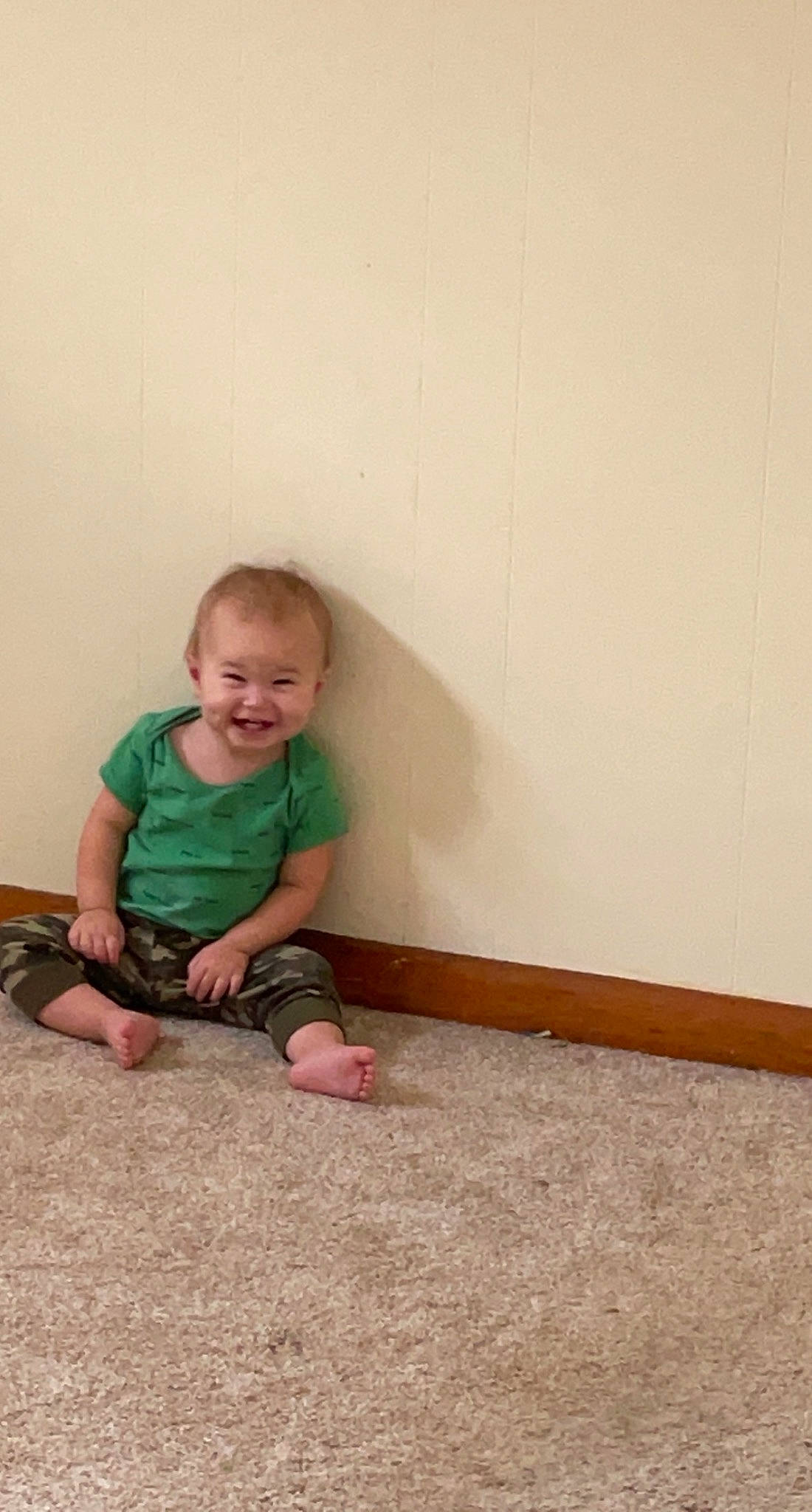 Scott is registered to the contest to win money with this photo: baby, baby_toddler_clothing, cheek, child, comfort, floor, flooring, foot, fun, grass, happy, hardwood, joy, person, room, shorts, sitting, sleeve, smile, t_shirt