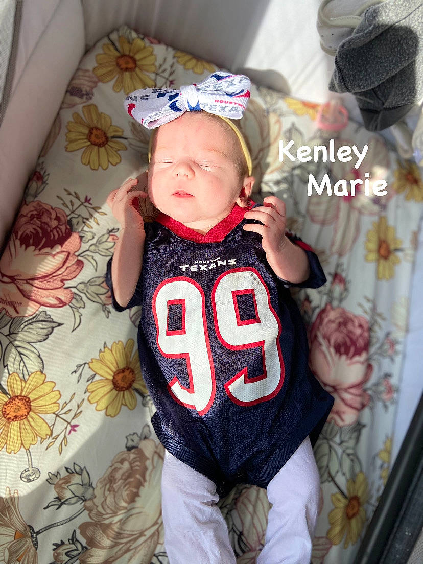 Kenley joined the competition — help win amazing prizes! baby, baby_toddler_clothing, baseball_cap, cap, couch, happy, hat, jersey, person, personal_protective_equipment, player, sleeve, sports_gear, sports_jersey, sports_uniform, sportswear, t_shirt, textile, thigh, toddler