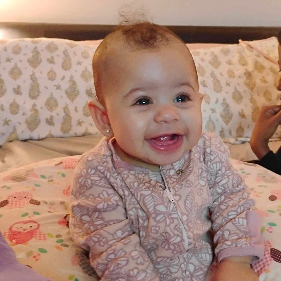 Samauri joined the competition — help win amazing prizes! baby, bed, child, comfort, cushion, cute, decor, face, hand, happy, home, indoors, infant, pajamas, patterned_clothing, pillow, sitting, sleepwear, smiling, soft_lighting