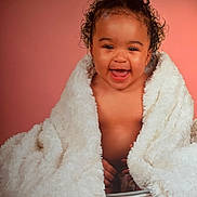 Keyssie a rejoint le concours — aidez-le/la à gagner de superbes lots ! baby, infant, child, blanket, smile, portrait, studio, pink_background, curly_hair, bucket, wrapped, cozy, laughing, eyes, chubby_cheeks, bare_chest, cute, fur_blanket, pose, soft_lighting