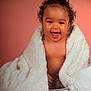 baby, infant, child, blanket, smile, portrait, studio, pink_background, curly_hair, bucket, wrapped, cozy, laughing, eyes, chubby_cheeks, bare_chest, cute, fur_blanket, pose, soft_lighting