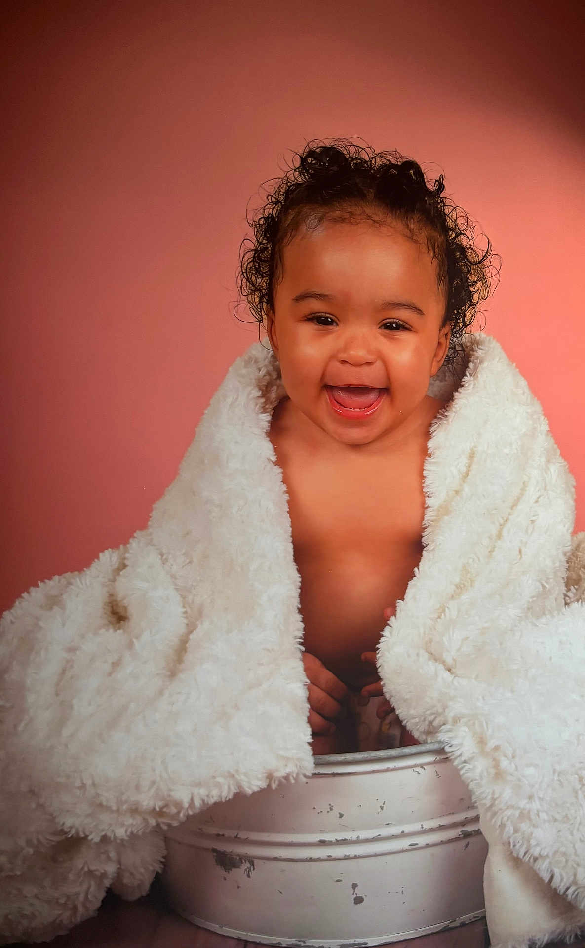 Keyssie a rejoint le concours — aidez-le/la à gagner de superbes lots ! baby, infant, child, blanket, smile, portrait, studio, pink_background, curly_hair, bucket, wrapped, cozy, laughing, eyes, chubby_cheeks, bare_chest, cute, fur_blanket, pose, soft_lighting