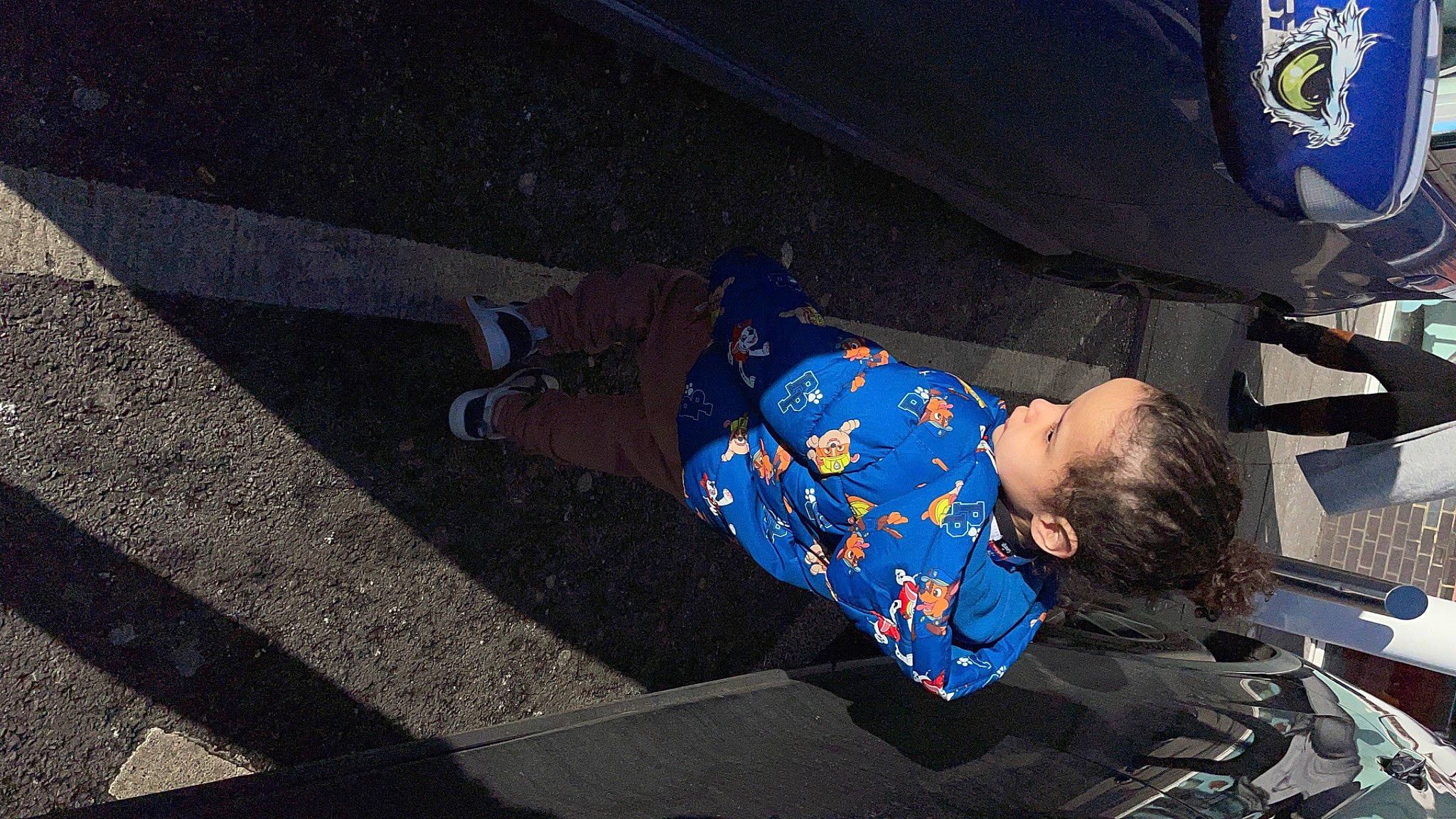 Gustavo is registered to the contest to win money with this photo: asphalt, auto_part, automotive_exterior, automotive_lighting, automotive_tire, automotive_wheel_system, bumper, city, electric_blue, fender, leisure, motor_vehicle, person, rim, road, road_surface, sidewalk, tire, toddler, tread