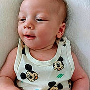 Kamel participe au concours pour gagner de l'argent avec cette photo : baby, infant, child, mickey_mouse, tank_top, clothing, cute, lying_down, white_background, soft_texture, skin, face, expression, hand, arm, person, portrait, closeup, indoors, comfortable