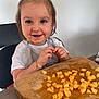 Amalia a rejoint le concours — aidez-le/la à gagner de superbes lots ! toddler, child, smiling, happy, melon, cutting_board, food, table, chair, hair_tie, bib, bracelet, indoor, person, cute, diced_food, wood, healthy, playful, casual