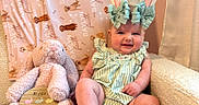 Baylyn joined the competition — help win amazing prizes! baby, bunny_ears, stuffed_animal, pink, striped_clothing, chair, blanket, easter, sign, smiling, indoors, cute, child, plush_toy, headband, pastel_colors, comfort, decor, holiday, portrait
