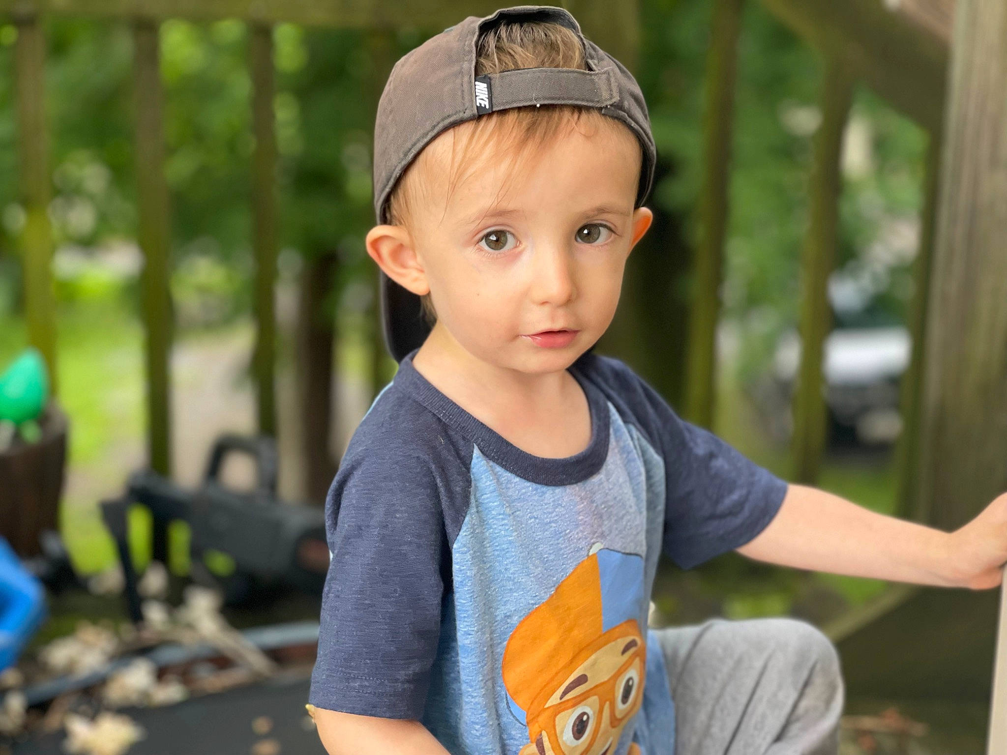 Lando is registered to the contest to win money with this photo: baseball_cap, cap, child, electric_blue, eyewear, fashion_accessory, fun, grass, happy, hat, leisure, person, portrait_photography, recreation, sitting, sleeve, summer, t_shirt, toddler, tree