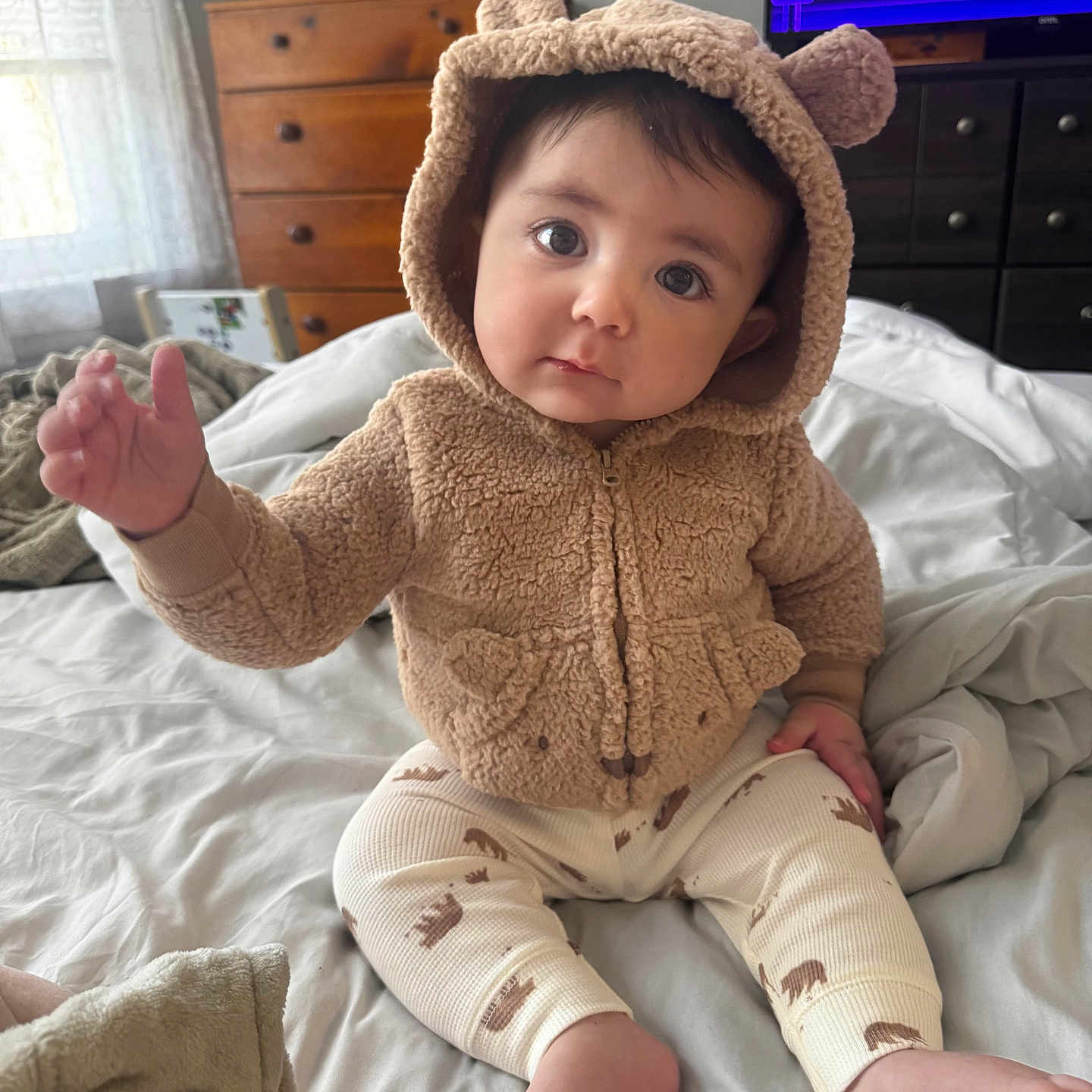 Cooper joined the competition — help win amazing prizes! baby, child, bed, blanket, clothing, cute, fuzzy_hoodie, indoor, infant, legs, person, plush, portrait, reaching_hand, sitting, television, wooden_drawer, window, eyes, expression