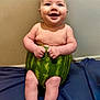 Hudson is registered to the contest to win money with this photo: baby, watermelon, fruit, smiling, sitting, happy, cute, infant, skin, barefoot, legs, hands, blue_fabric, indoor, wall, playful, funny, child, portrait, candid