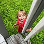 Liala is registered to the contest to win money with this photo: child, toddler, red_dress, smiling, curious, wooden_railings, grass, outdoor, steps, person, portrait, baby, nature, playful, greenery, cute, young_child, hand, standing, daylight