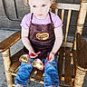 apron, bow, casual_clothing, child, curious, floor, hair, indoor, jeans, person, pink, portrait, purple, rocking_chair, seated, shoes, sunglasses, texture_effect, toddler, wood