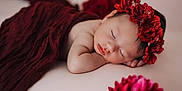Ava a rejoint le concours — aidez-le/la à gagner de superbes lots ! baby, sleeping, flower_crown, red_cloth, soft_surface, portrait, peaceful, infant, close_up, skin, head, face, resting, flower, blurred_background, cute, newborn, soft_lighting, indoors, calm