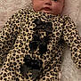 baby, infant, leopard_print, onesie, black_bows, blanket, fluffy, soft, cute, lying_down, sleepwear, child, portrait, face, eyes, skin, head, cozy, comfortable, indoor