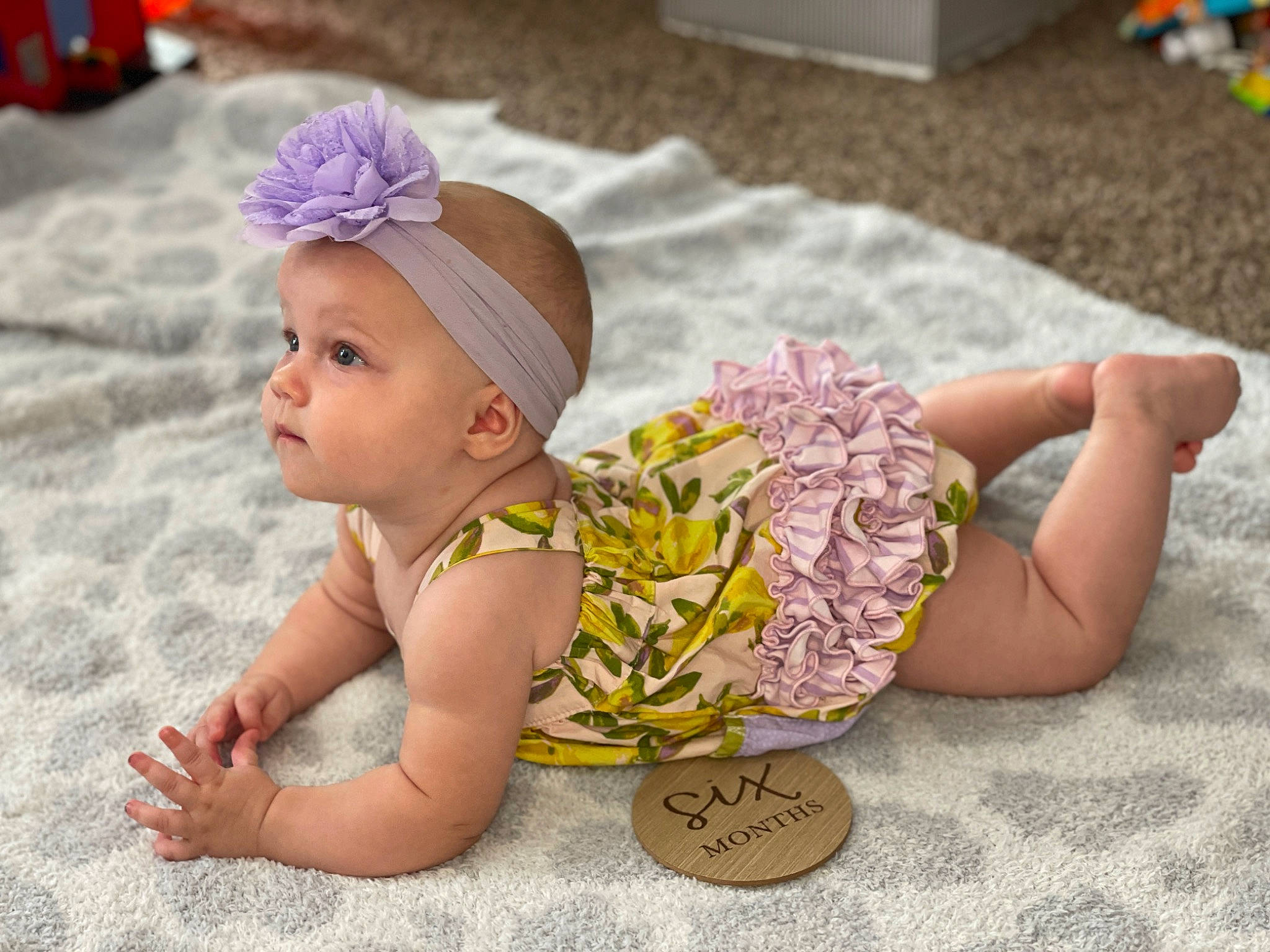 Breleigh is registered to the contest to win money with this photo: baby, baby_toddler_clothing, cap, child, comfort, fashion_accessory, flooring, fun, grass, hair_accessory, happy, headband, headgear, headwear, pattern, person, pink, purple, sitting, skin