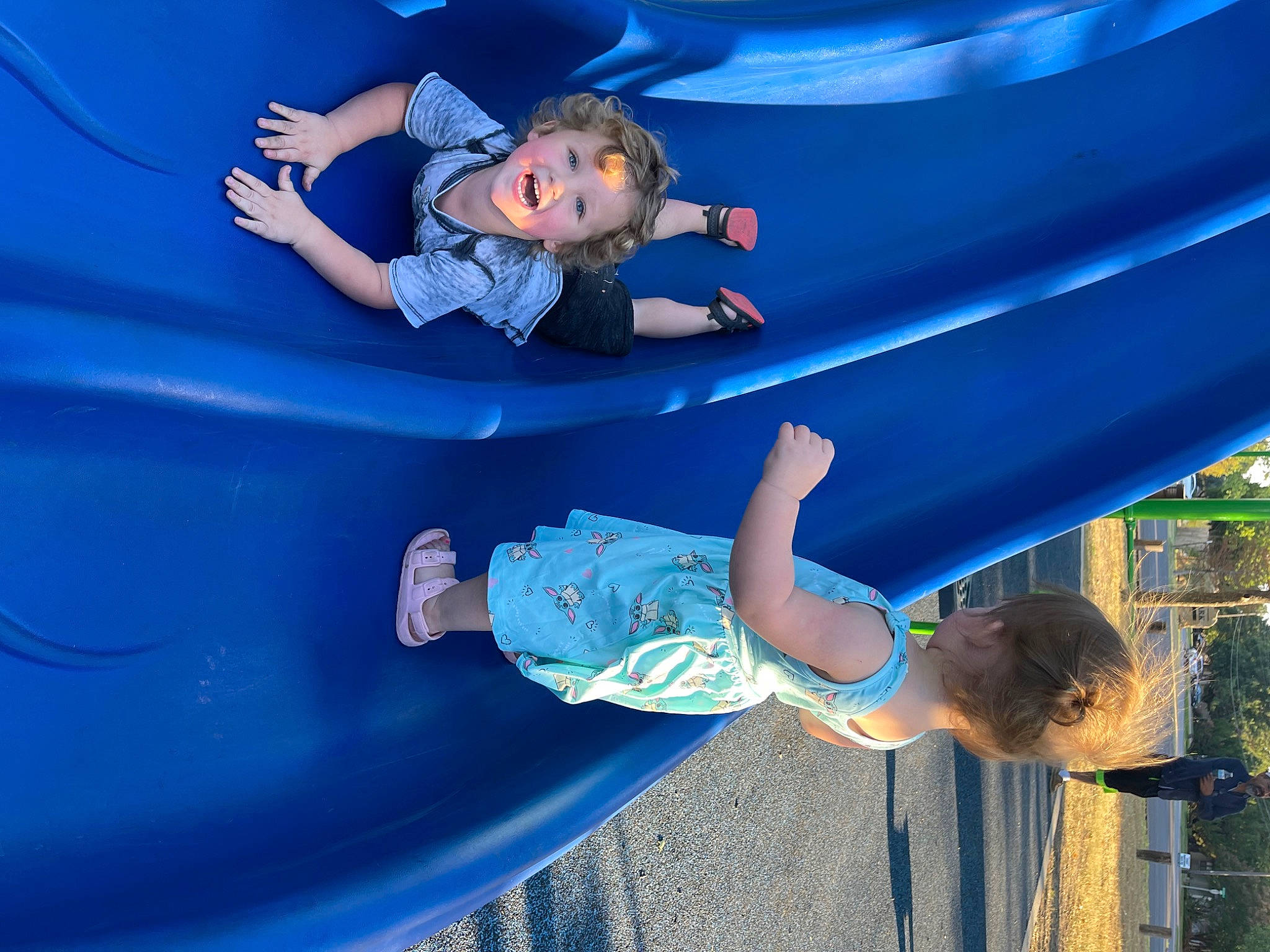 Brycen is registered to the contest to win money with this photo: arm, automotive_exterior, blue, bumper, child, chute, city, electric_blue, fun, happy, hood, leisure, outdoor_play_equipment, person, play, playground, recreation, smile, snapshot, toddler