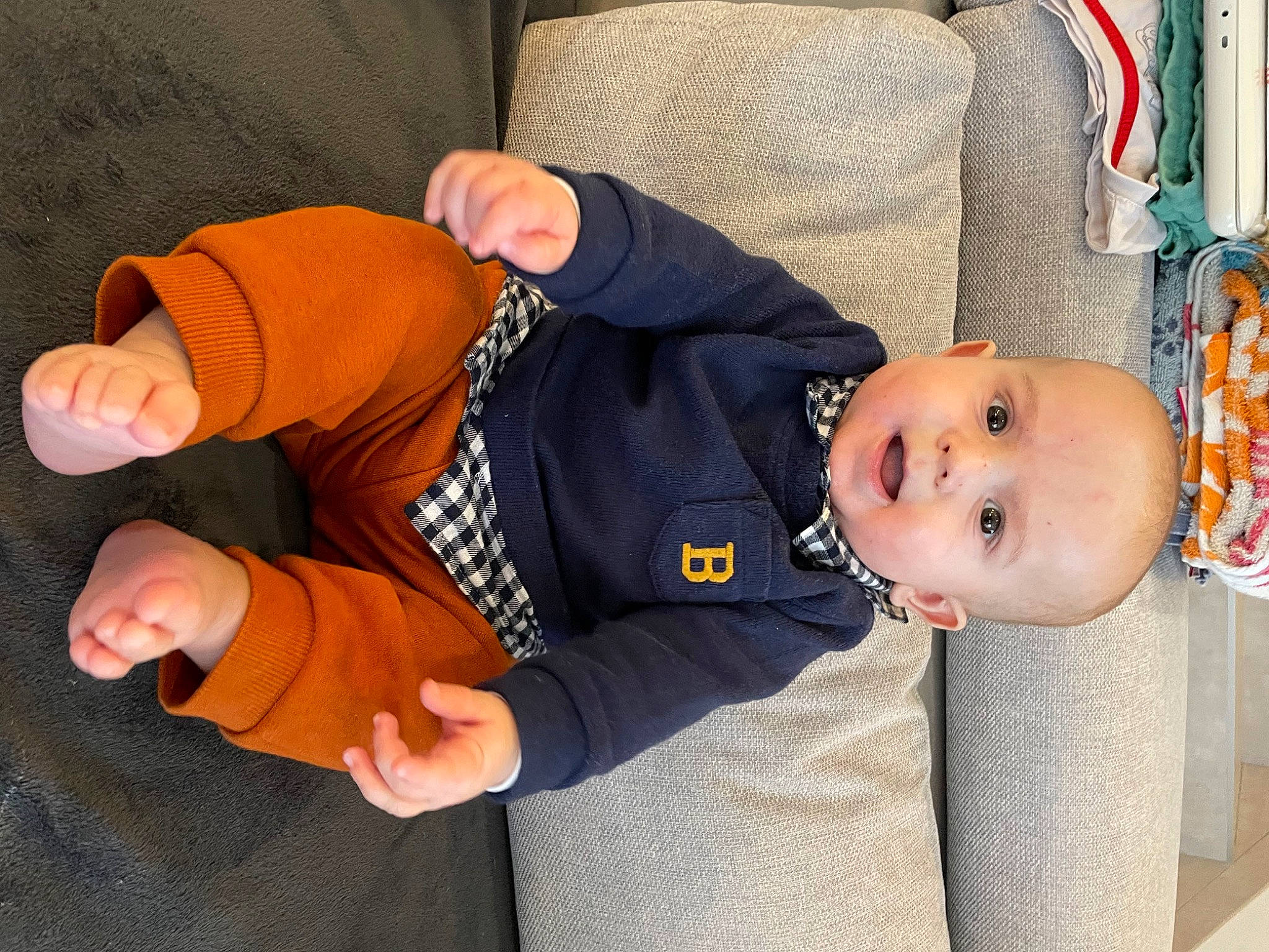 Mael participe au concours pour gagner de l'argent avec cette photo : baby, baby_products, baby_toddler_clothing, child, comfort, gesture, human_body, lap, person, product, sitting, sleeve, smile, thumb, toddler