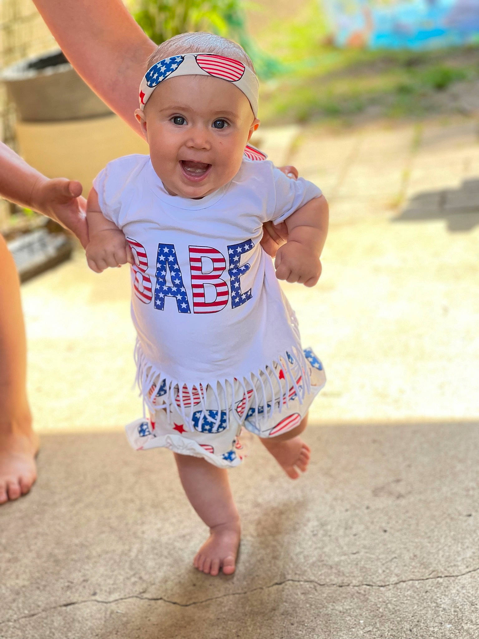 Emyrson is registered to the contest to win money with this photo: baby, baby_toddler_clothing, barefoot, beach, body_of_water, child, foot, fun, gesture, happy, hat, headwear, human_leg, leisure, people_on_beach, person, recreation, sand, sleeve, smile