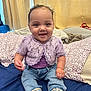 baby, child, smiling, sitting, clothing, jeans, cardigan, purple, bed, pillow, blanket, indoor, cute, happy, face, person, footwear, headband, curly_hair, infant