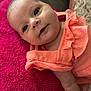 baby, infant, face, child, pink_towel, orange_clothing, ruffles, portrait, cute, smile, skin, head, lying_down, young_child, indoor, closeup, expression, person, soft_texture, bright_colors